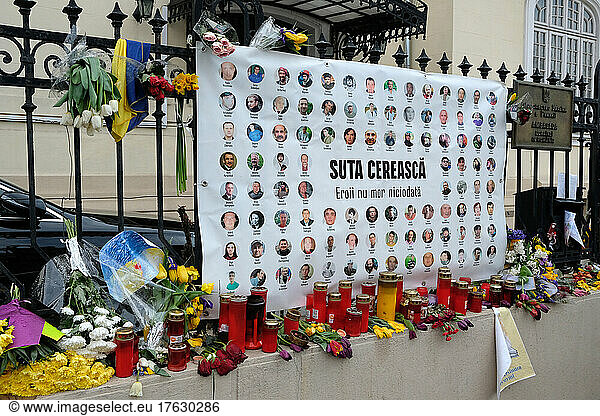 On the gates of the Embassy of Ukraine - Bucharest - Romania flowers  banner designs to pay tribute to the Ukrainians who died in the war