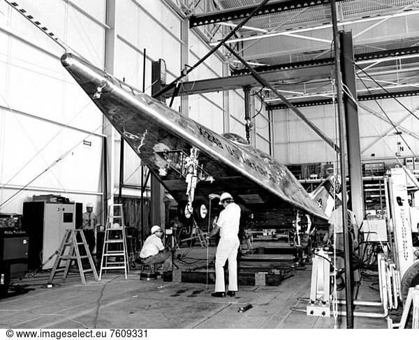 Once a new research vehicle is delivered to Dryden from the contractor  it must undergo months of ground checkout before making its first flight. The X_24B lifting body is no exception. Here it is shown undergoing landing gear drop tests. As part of the modifications to convert the vehicle from the X_24A configuration  the nose gear from an F11F_1 was retrofitted to the X_24B. In these tests  the X_24B´s nose was raised a measured distance above the hangar floor an engineer can be seen holding a tape measure  and then released  allowing the nose gear to hit the floor. This tested the landing gear´s ability to withstand the shock of touchdown  without sustaining damage to it or the aircraft´s structure.