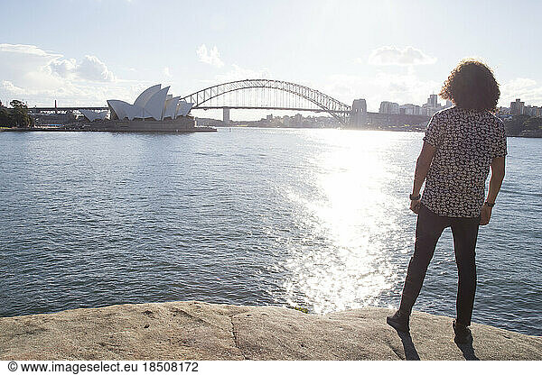 One man during golden hour  staring at the Sydney Opera House