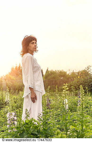 One Mexican woman wearing all white at flower field during sunset