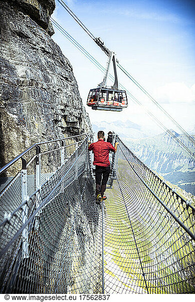 One person looking at the cable car from the Thrill Walk cliff pathway  Murren Birg  Jungfrau Region  Bern canton  Switzerland  Europe