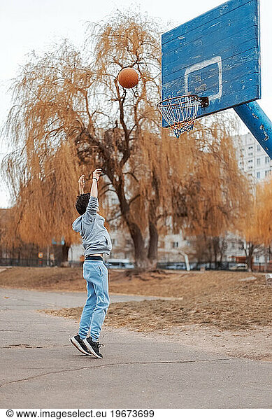 One young person playing basketball.