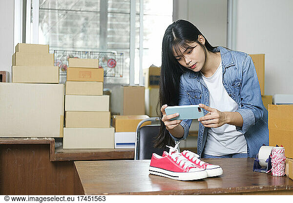 Online seller owner take a photo of product for upload to websit