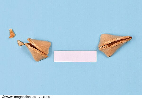 Open fortune cookie with note without text on blue background
