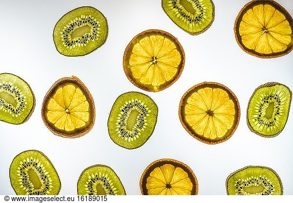 Orange and kiwi in slices  white background  food photography