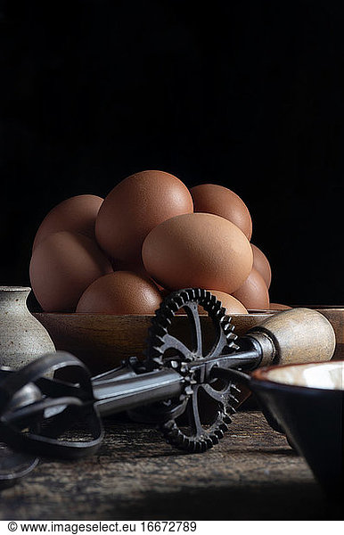 organic chicken eggs vertical with a iron whisk  room for text