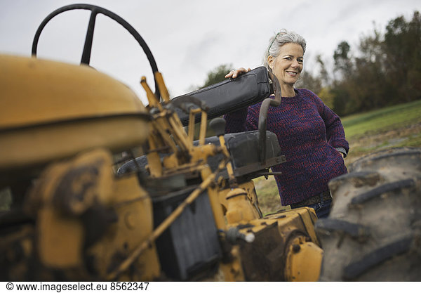 Organic Farmer at Work. A woman by a tractor.