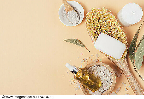 Organic oil with natural bathroom supplies on beige background