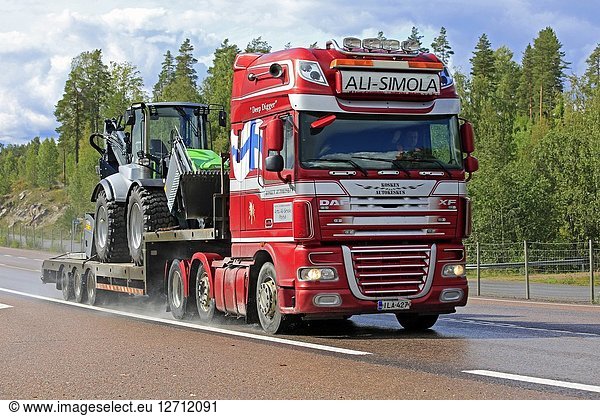 Orivesi  Finland - August 27  2018: DAF XF truck of Ali-Simola transports agricultural tractor on gooseneck trailer along wet highway on a rainy day.