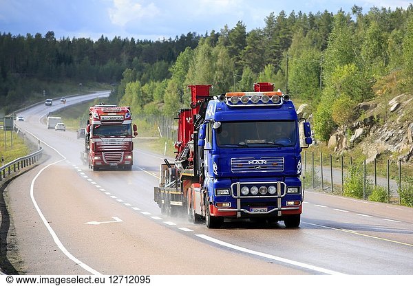 Orivesi  Finland - August 27  2018: Two semi trucks transport heavy machinery on wet road in Central Finland on a rainy day of late summer.