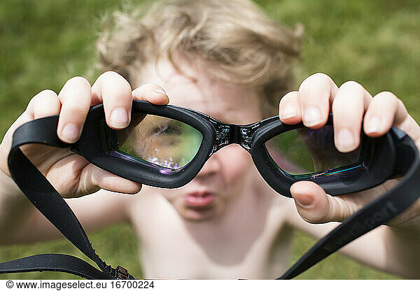 Out of Focus Little Boy Looks Through In Focus Pair of Goggles