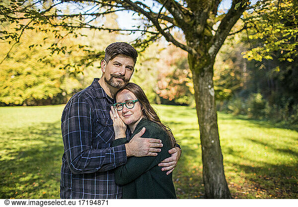 Outdoor-Porträt eines Paares im Millennial-Alter  das sich umarmt.