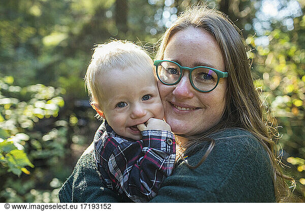 Outdoor portrait of a mother holding her one year old son.