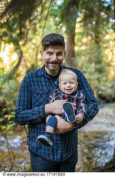 Outdoor portrait of father and son smiling.