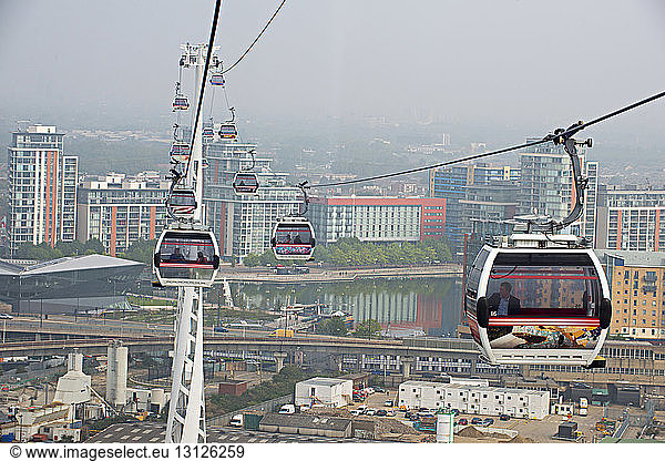 Overhead cable cars in city against sky