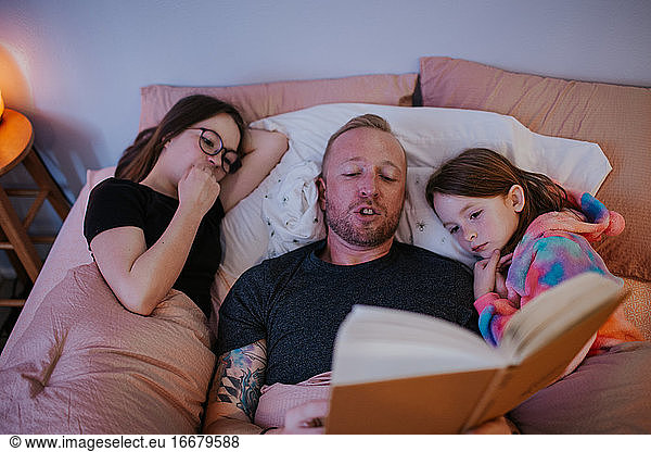 overhead of dad reading to children