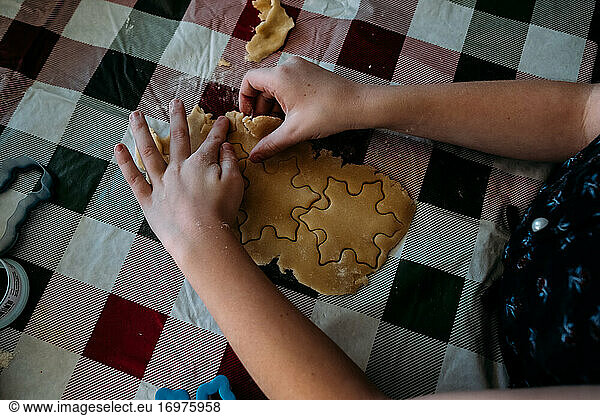 Overhead of young girl using cookie cutters