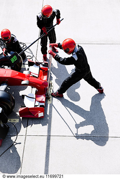 Overhead pit crew with hydraulic lift in pit lane