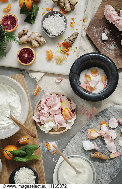 Overhead view of a pestle and mortar and rose petals  ginger and oranges
