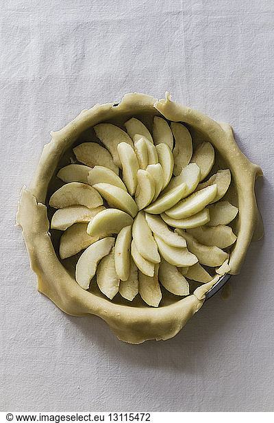 Overhead view of apple slices in pie dough on table