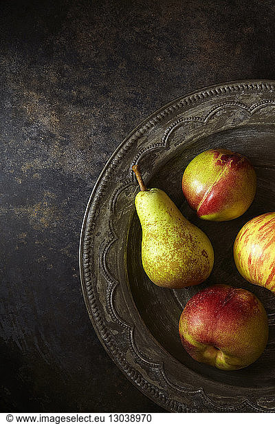 Overhead view of apples and pear in metallic plate