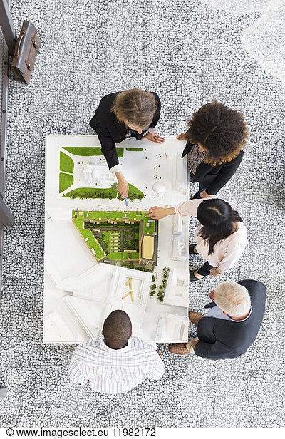 Overhead view of architects discussing blueprint
