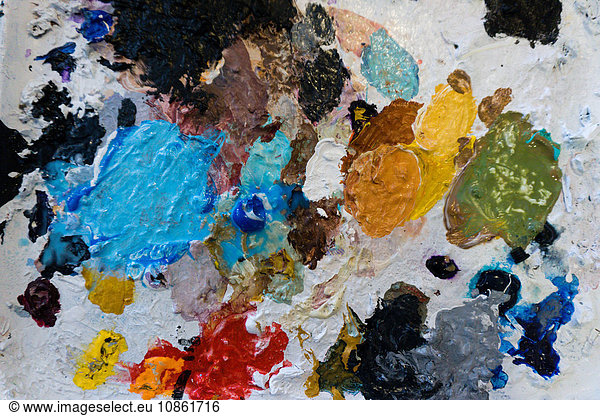 Overhead view of artist palette splodged with dried colorful paint