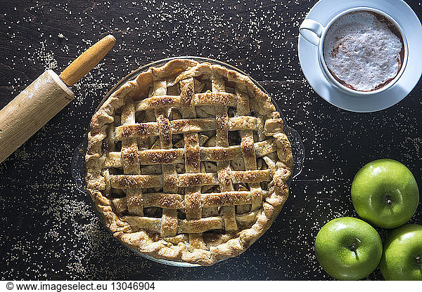 Overhead view of baked green apple pie on wooden table