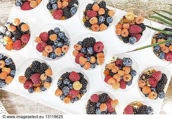 Overhead view of berry fruits in bowls arranged on table