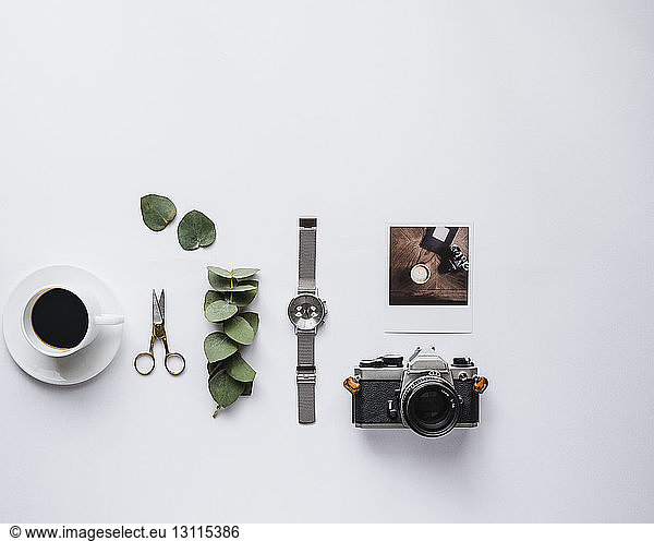 Overhead view of black coffee with accessories against white background