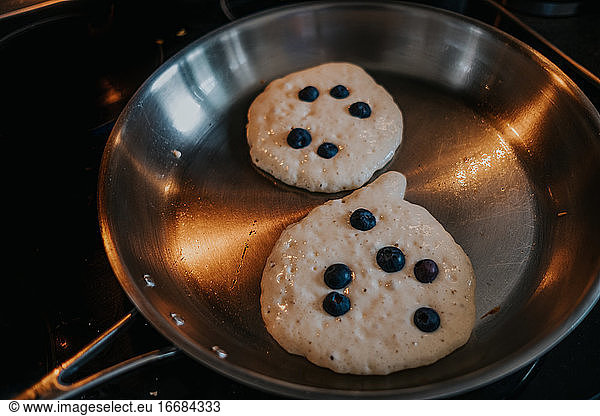 overhead view of blueberry pancakes in pan