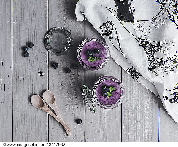 Overhead view of blueberry smoothies by textile on table