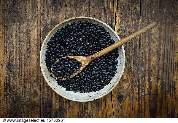 Overhead view of bowl of black bean on wooden table