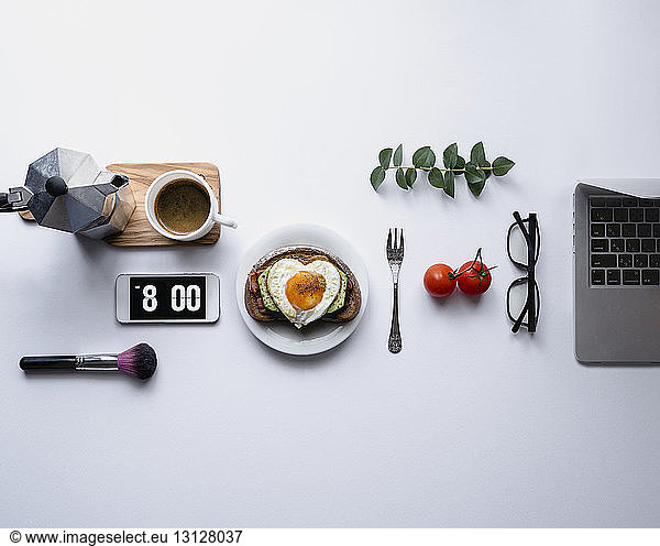 Overhead view of breakfast with accessories against white background