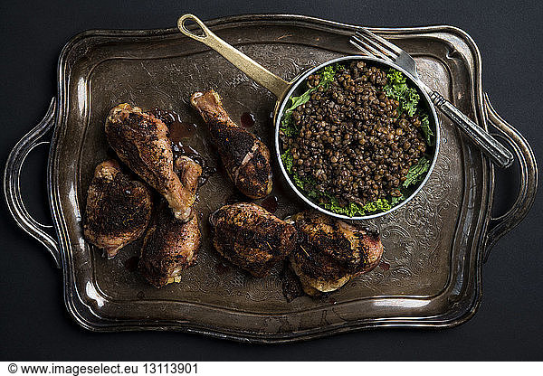 Overhead view of chicken with lentils and kale dish in tray