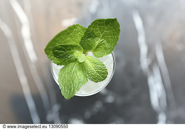 Overhead view of drink garnished with mint leaves in drinking glass