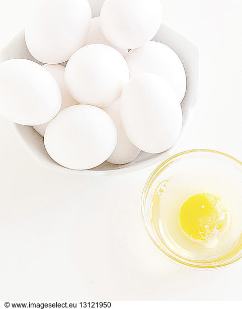 Overhead view of eggs in bowls on white background