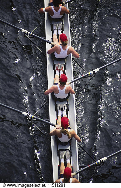 Overhead view of female crew racers rowing a sports racing shell. boat