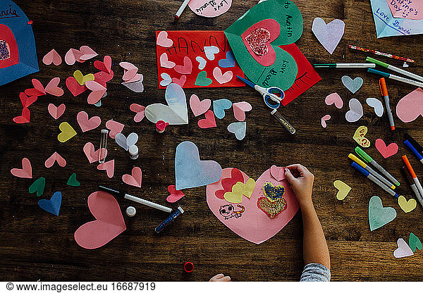 Overhead view of girl creating valentines crafts and cards