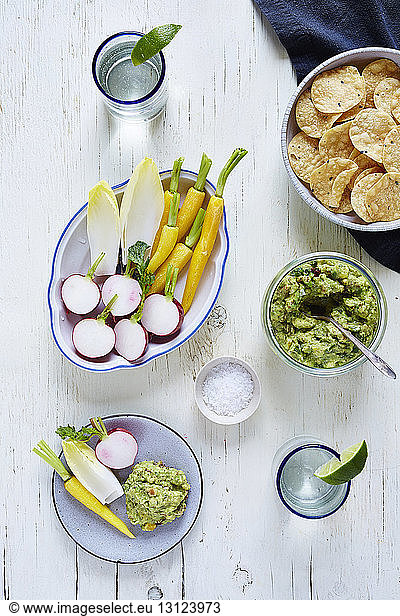 Overhead view of guacamole and vegetables on table