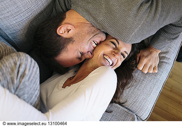 Overhead view of happy couple on sofa at home
