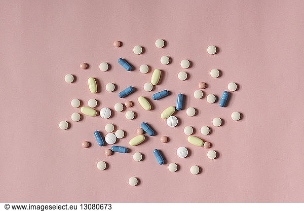 Overhead view of medicines over coral background
