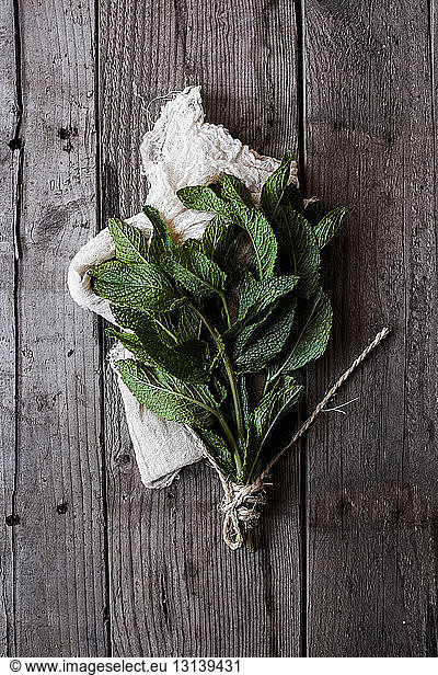 Overhead view of mint leaves bunch on wooden table