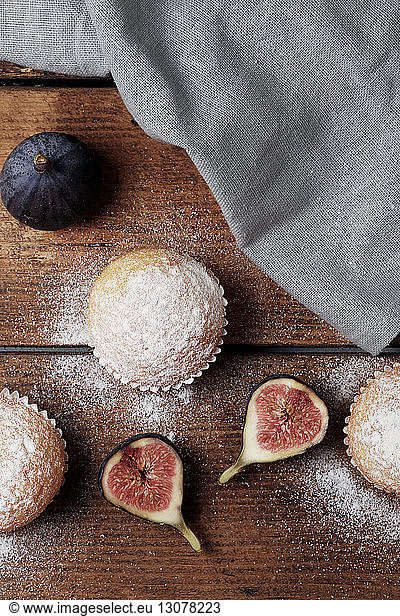Overhead view of muffins with figs and napkin on wooden table