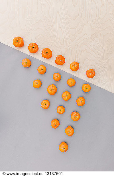 Overhead view of oranges arranged in triangle shape on table
