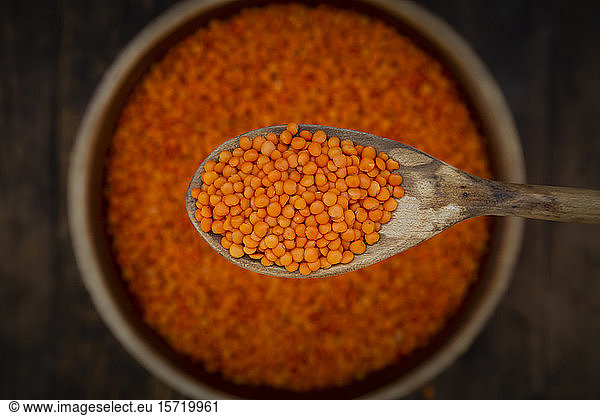Overhead view of organic red lentils on wooden spoon