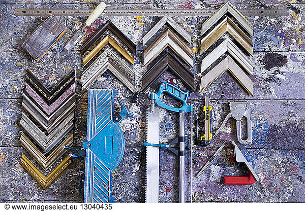 Overhead view of picture frame corners with work tools on table in workshop