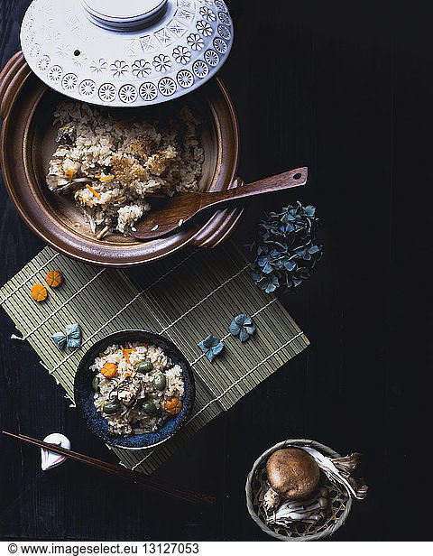Overhead view of rice and mushrooms on black table