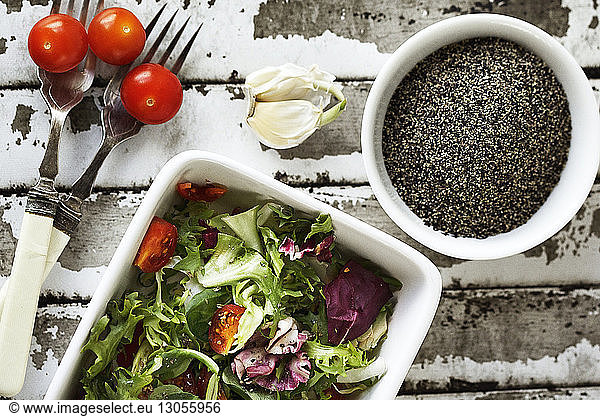 Overhead view of salad and black peppercorn on table