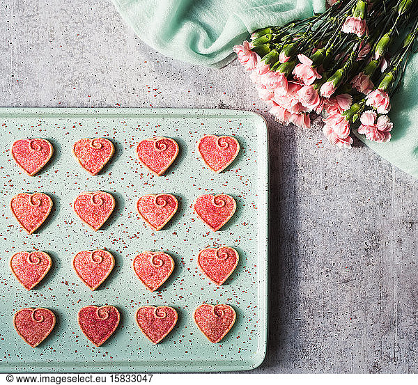 Overhead view of Valentine's day heart cookies cooling on a pan.